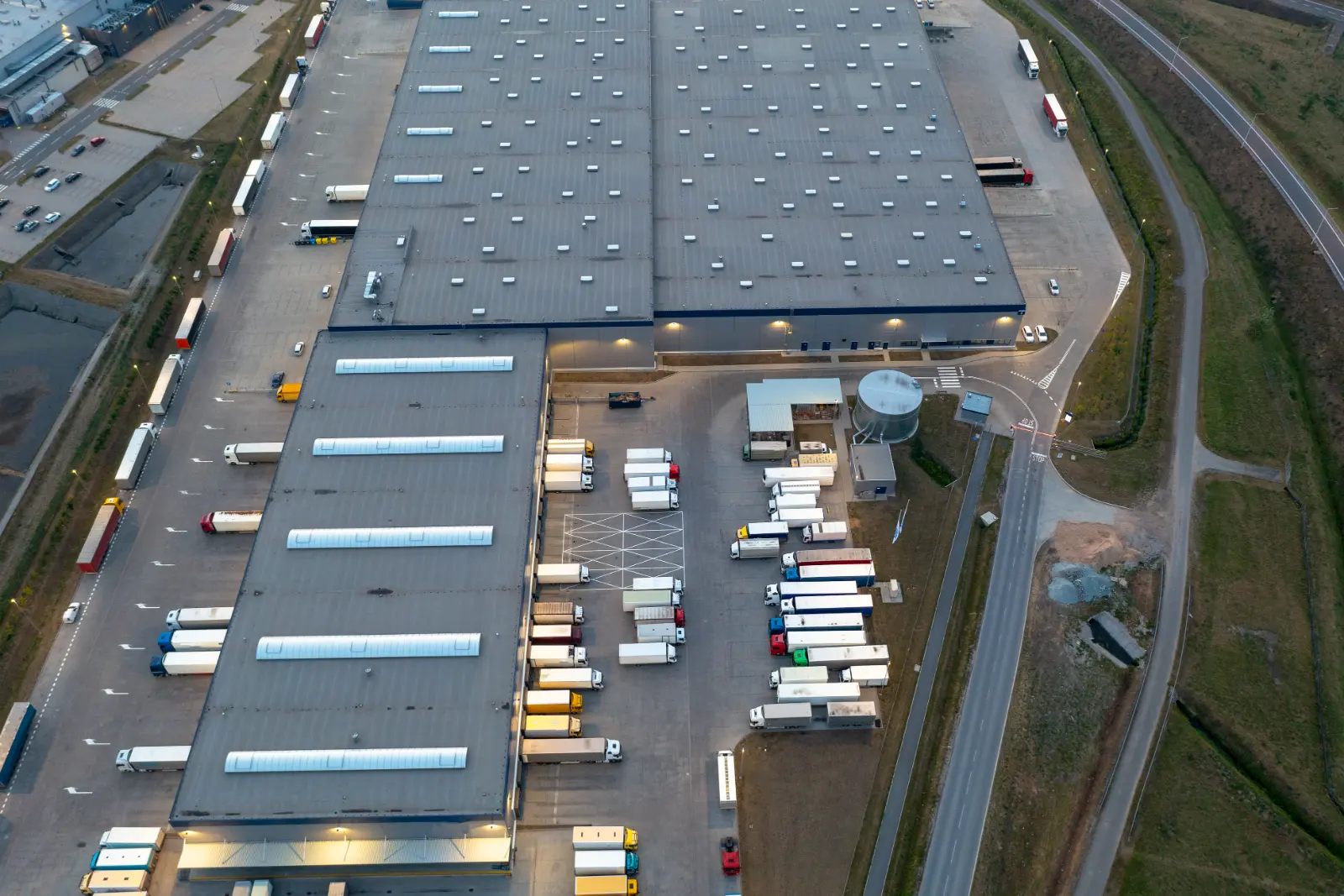 Draufsicht auf ein Lager mit wartenden Lastwagen vor den Laderampen