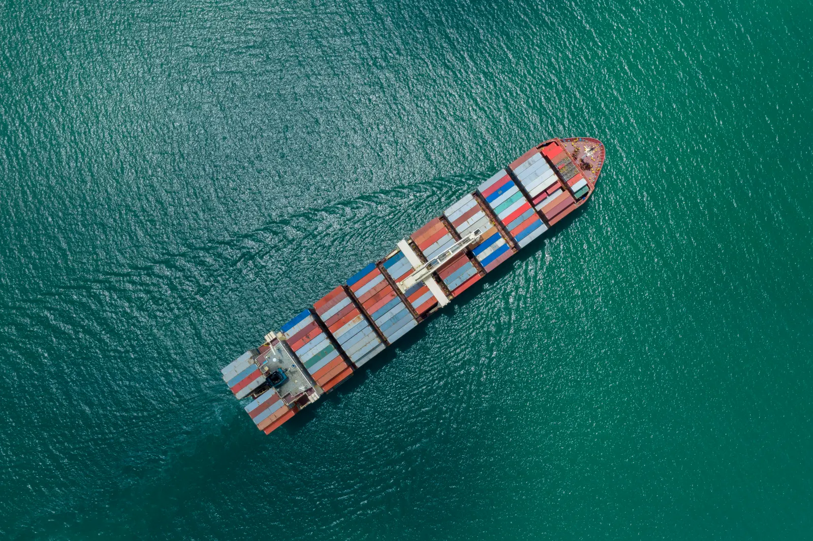 Luftaufnahme eines Containerschiffs mit Fracht auf offener See