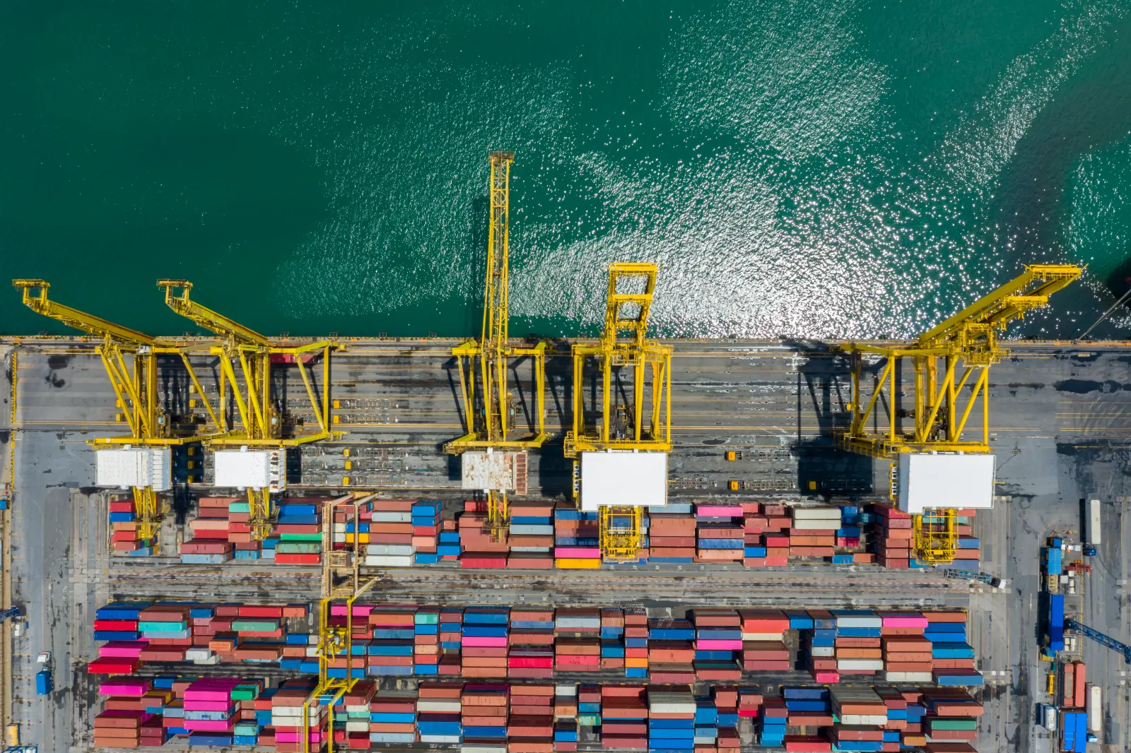 Luftaufnahme eines Containerterminals mit Verladekran am Meer